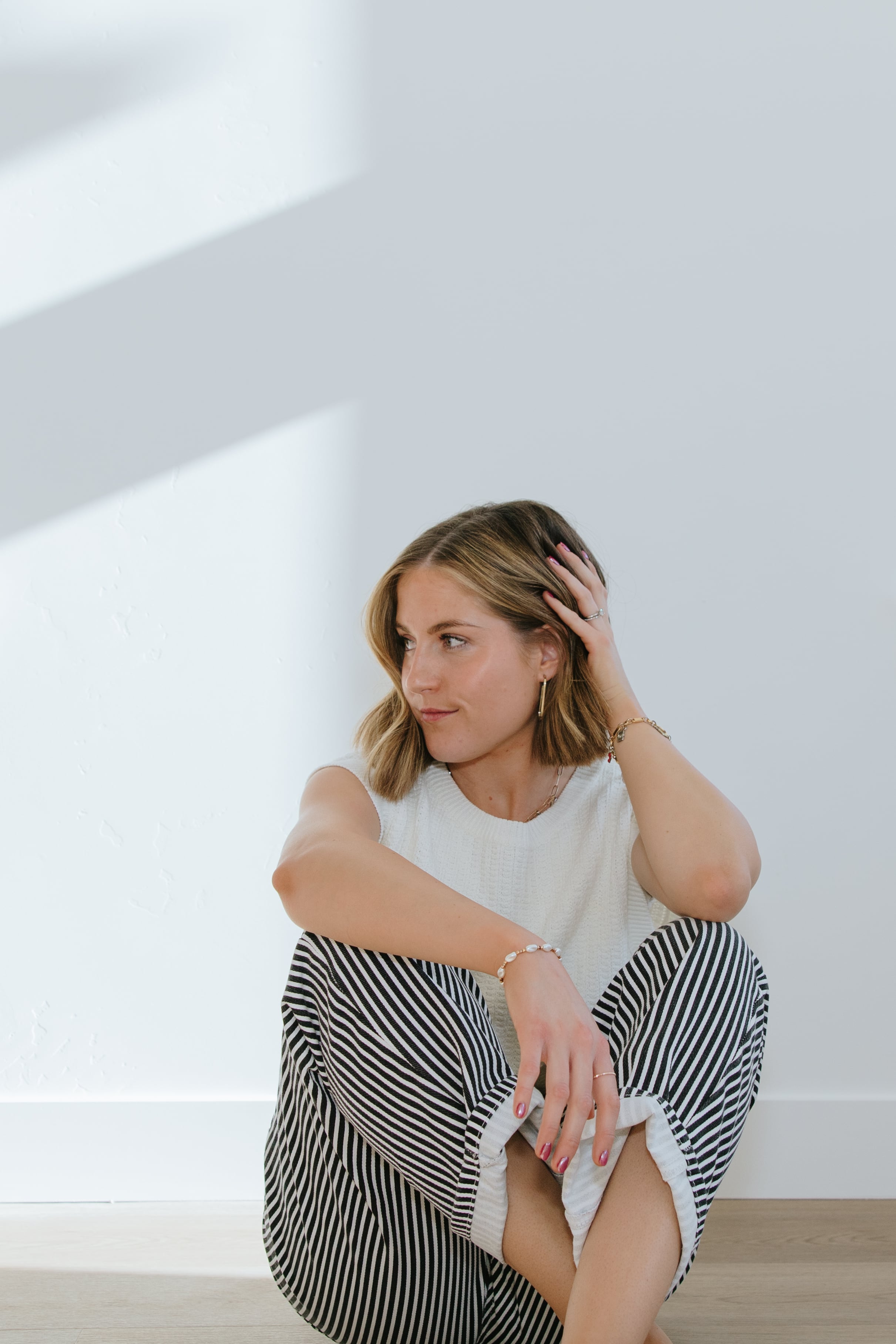 Kait, the business owner, smiling in a white sweater while holding a camera