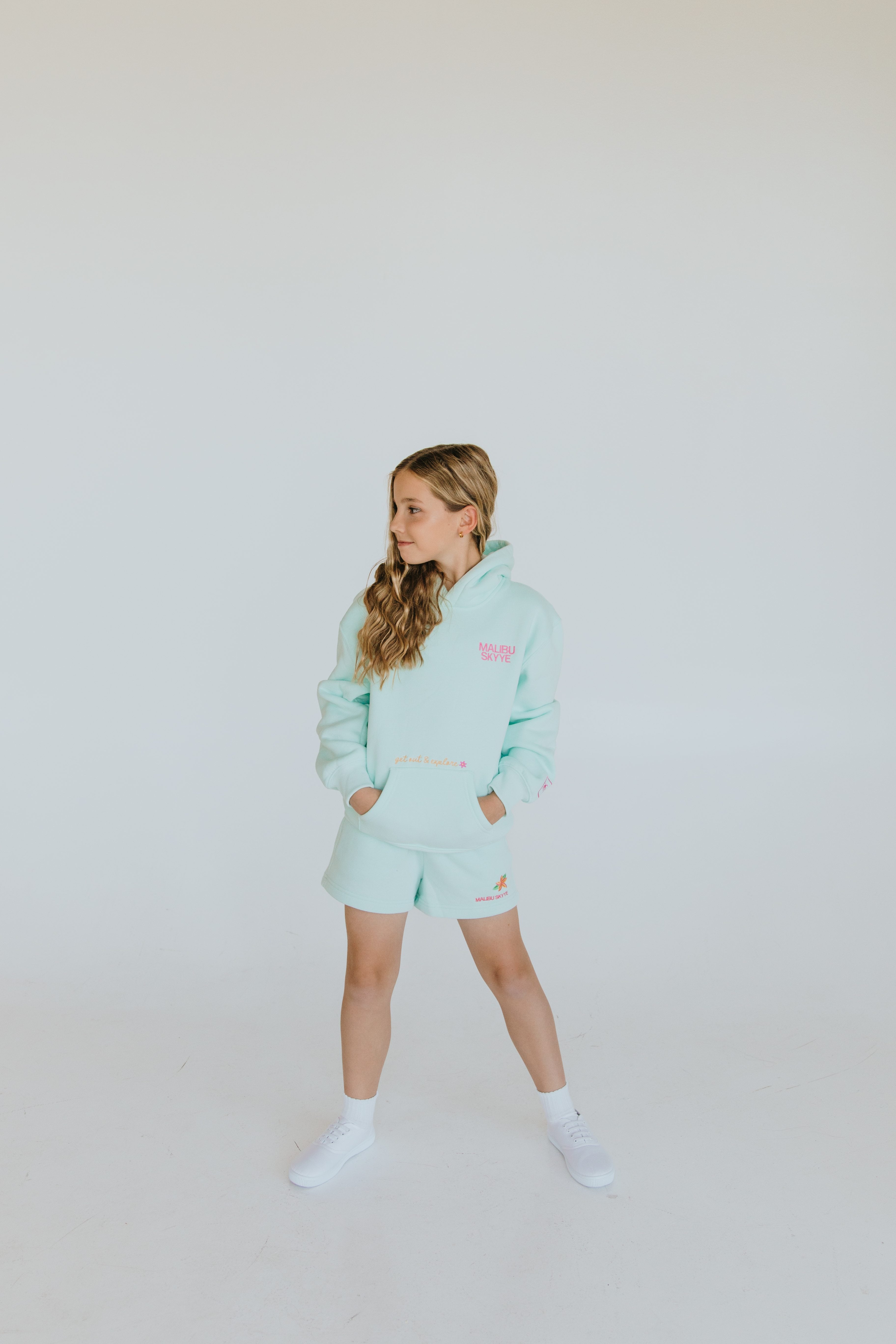Young model wearing a mint Malibu Skyye hoodie and shorts.