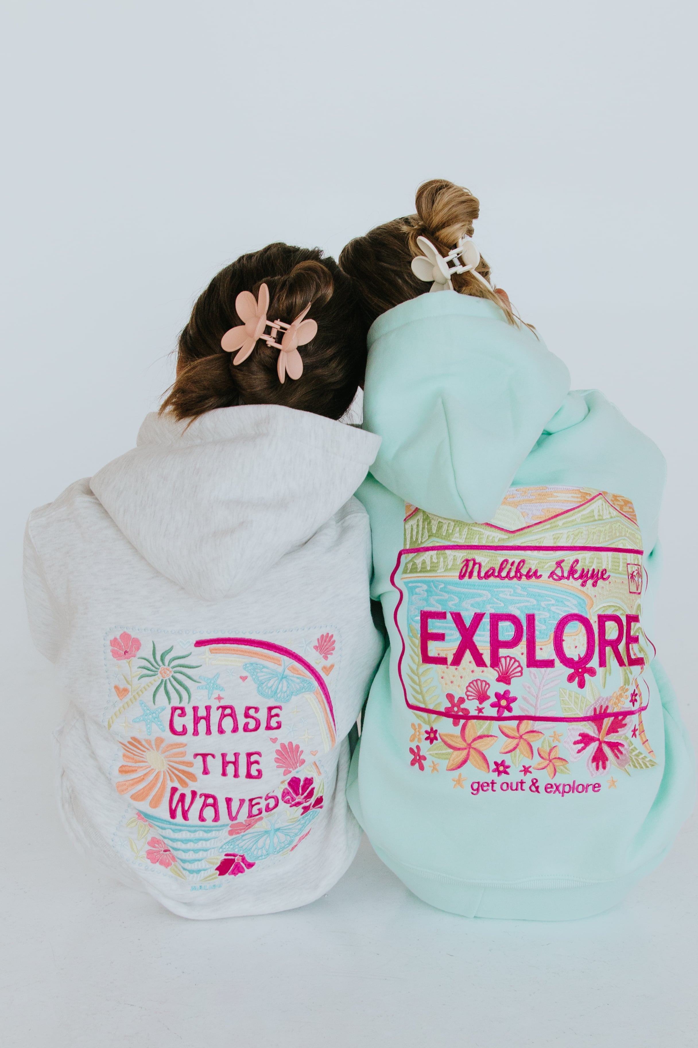 Two people photographed from behind wearing Malibu Skyye clothing.